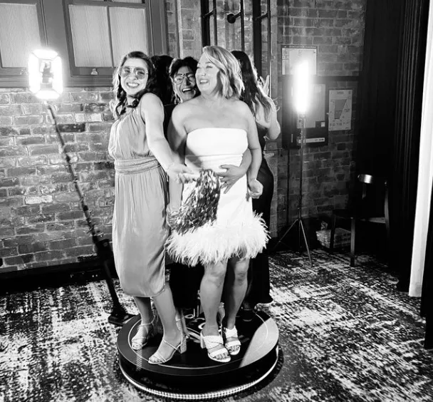 Group of women enjoying a 360 Video Booth experience, posing playfully on a rotating platform in a stylish event setting, highlighting engagement and fun at a Double Bay event.