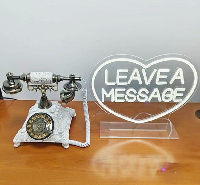 Vintage-style telephone and illuminated "LEAVE A MESSAGE" sign, symbolising Halo 360's audio guestbook service for capturing event memories.