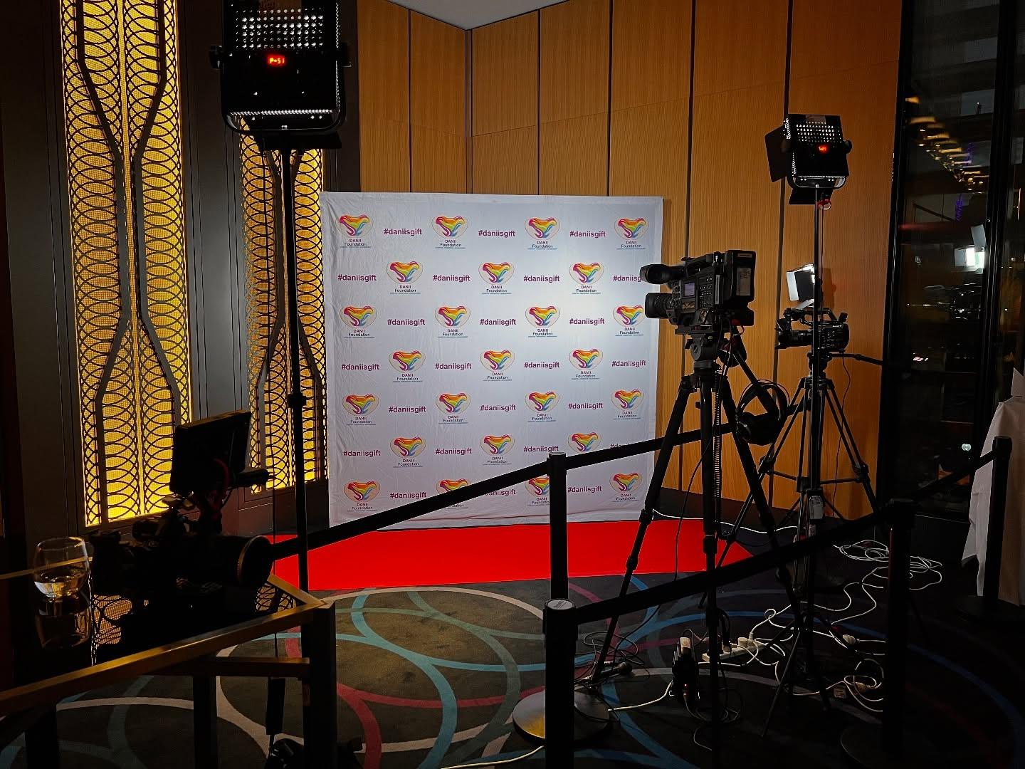 Event photography setup featuring cameras and lighting equipment in front of a branded backdrop with #danisgift, showcasing professional services for corporate and commercial events in Sydney.