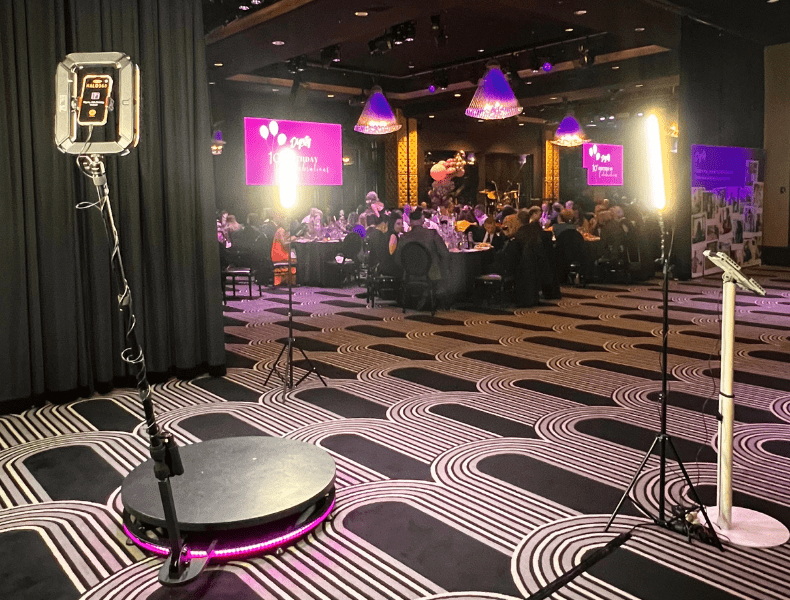 360 photo booth setup with professional lighting and backdrop in a stylish event venue, showcasing a vibrant atmosphere for weddings and celebrations.