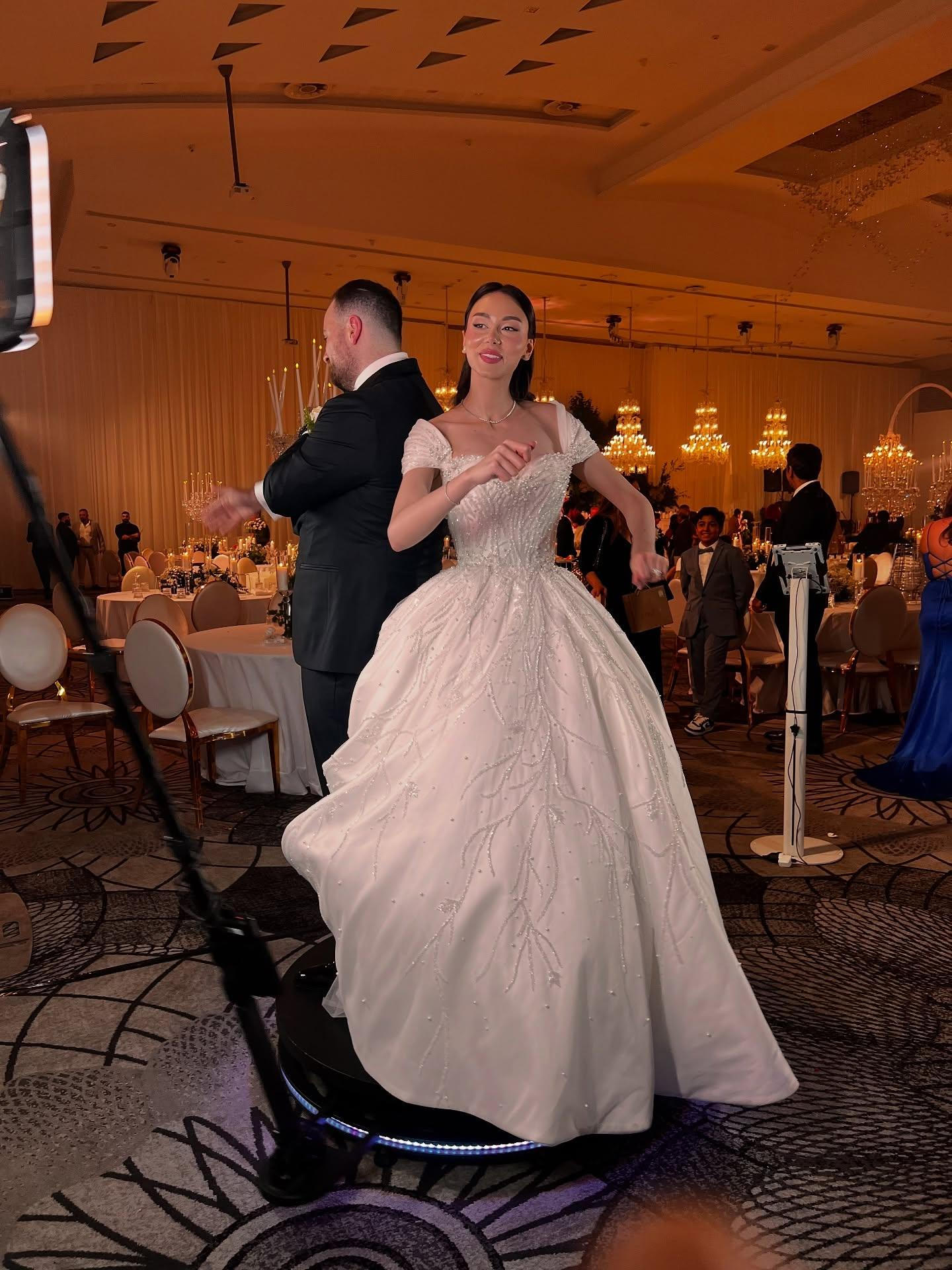 Guests enjoying a 360 booth at a wedding, capturing memorable moments with a festive atmosphere
