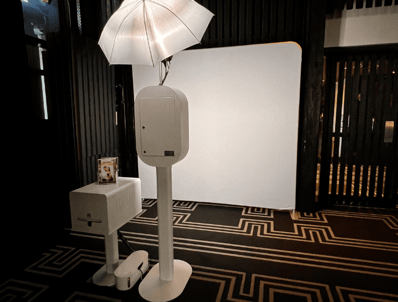 White photo booth setup with umbrella lighting and blank backdrop, designed for premium wedding experiences, emphasizing professionalism and quality service by HALO360.